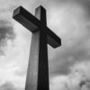 concret cross against a black and white sky