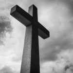 concret cross against a black and white sky