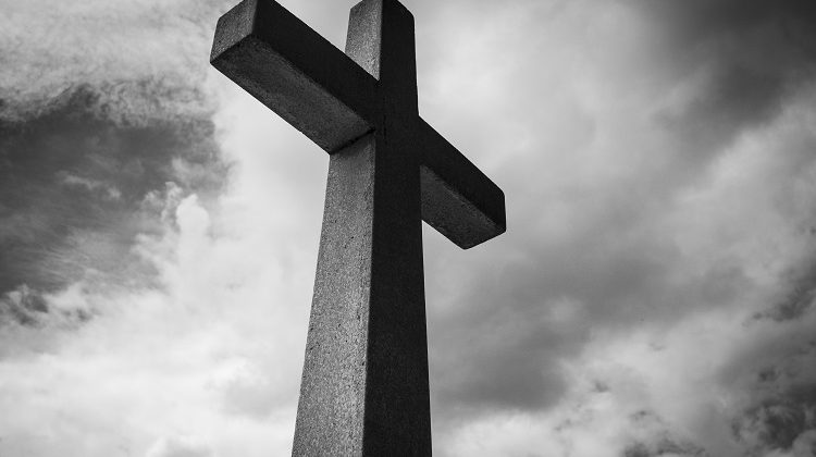 concret cross against a black and white sky
