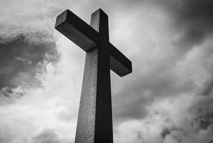 large cross against a black and whit sky